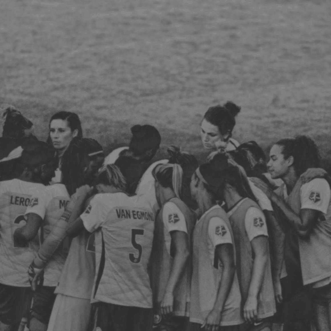 Group of women soccer players in a huddle.