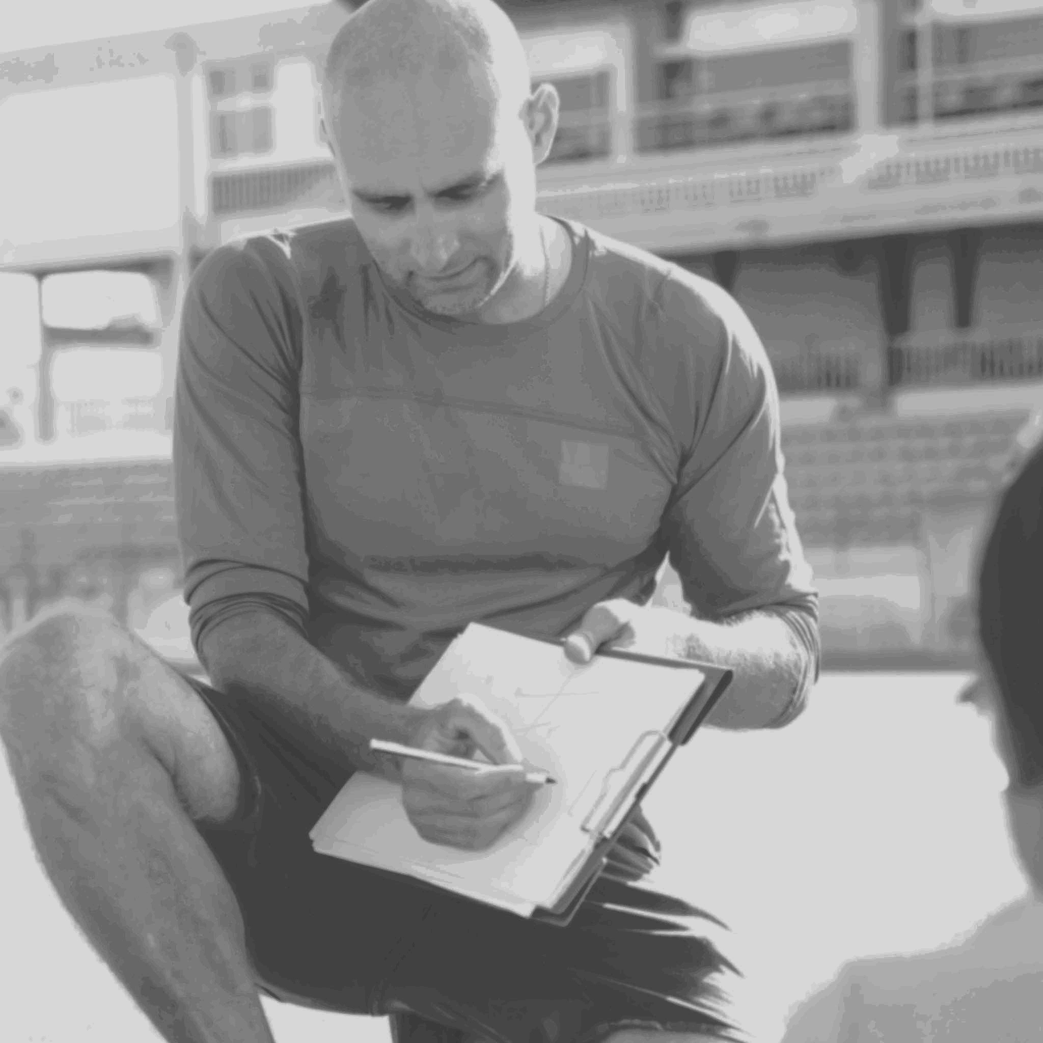 A soccer coach drawing on a whiteboard.